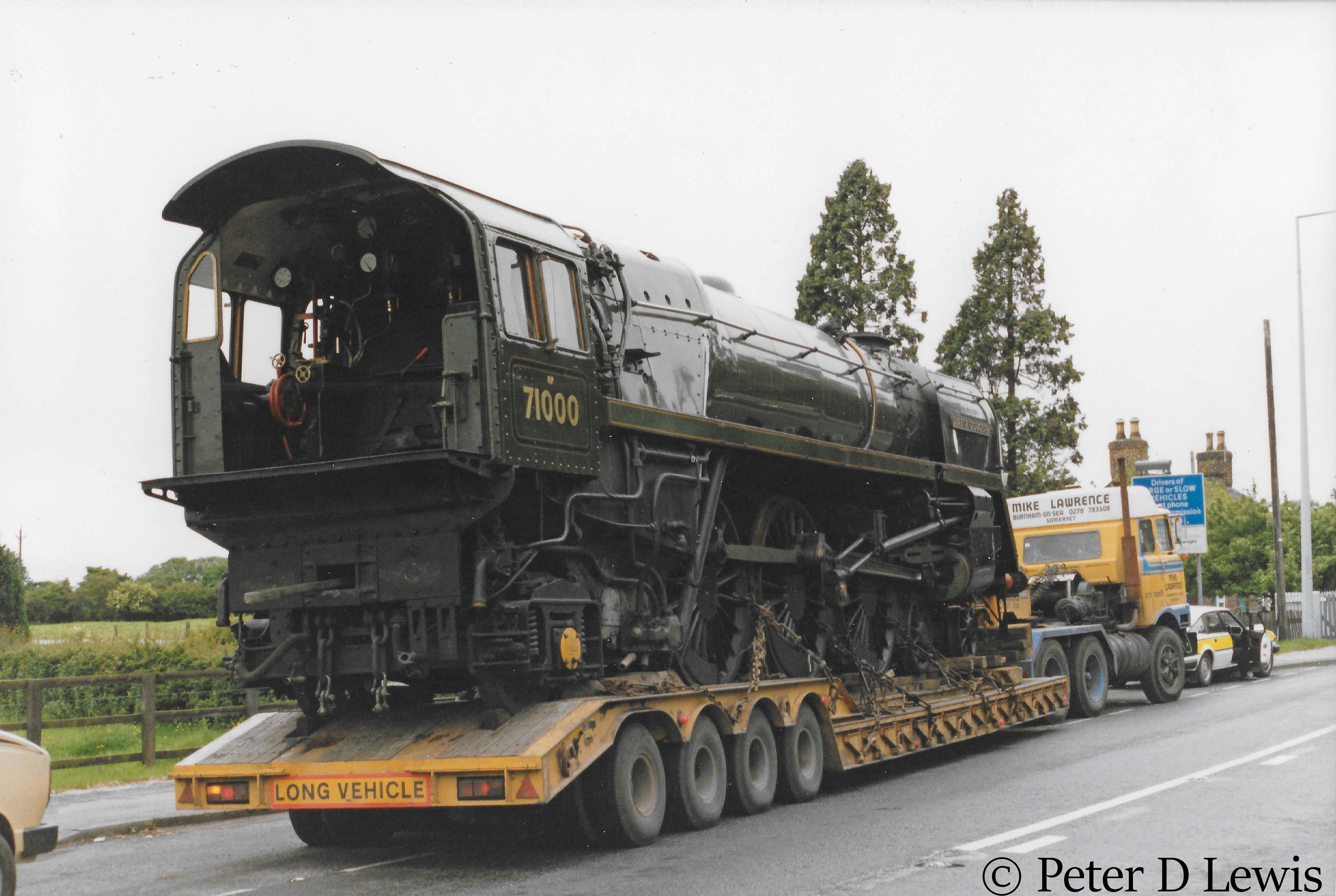 This image has an empty alt attribute; its file name is 71000-duke-of-gloucester-in-transit-at-nantwich-in-cheshire-waiting-for-clearance-to-cross-the-tracks-at-london-road-crossing-date-unknown.jpg